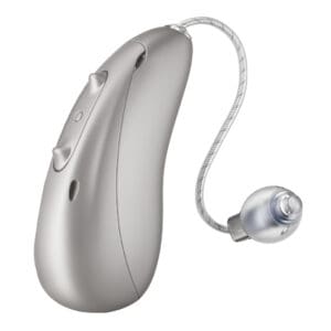 Silver behind-the-ear hearing aid with two buttons and a clear tube leading to a round earpiece